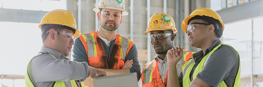 Four workers discussing safety plans