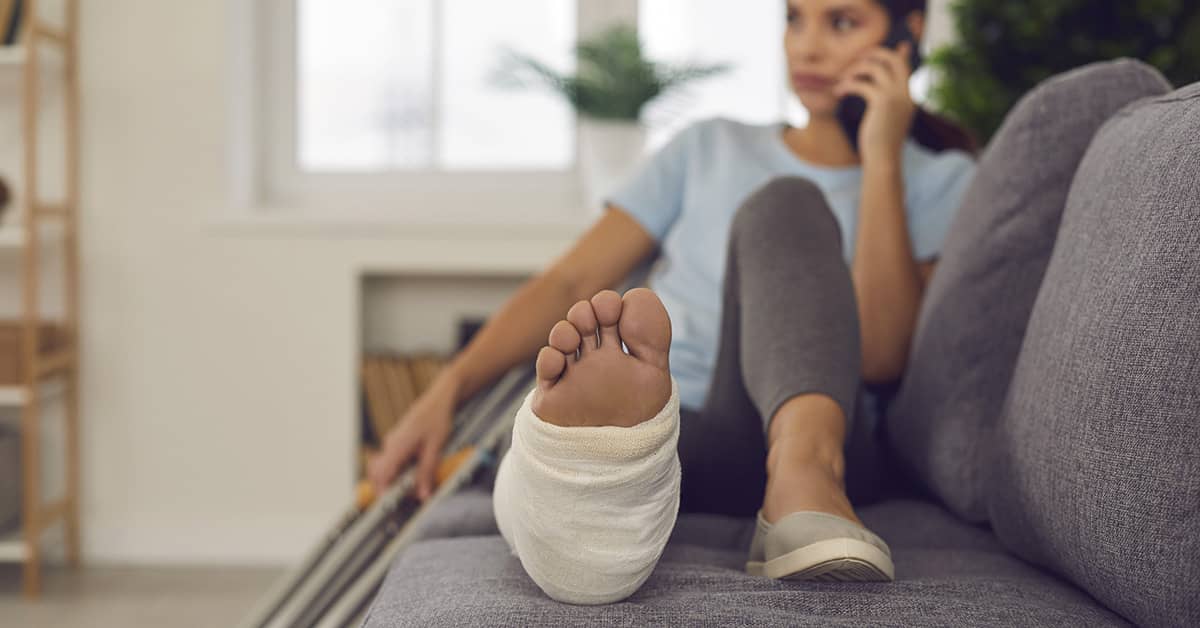 Injured employee with bandaged foot resting at home, crutches nearby—illustrating OSHA days away from work scenario.