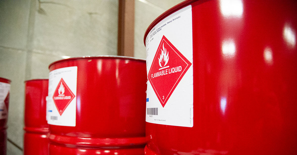 Red barrels labeled with flammable liquid warning in an industrial storage area, emphasizing safety and hazard management.