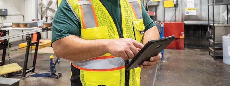 safety professional viewing company portal on tablet in workplace
