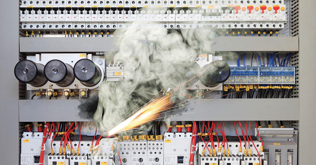 Electrical panel emitting sparks and smoke due to a fault, illustrating shock hazards and the need for proper electrical safety and maintenance in the workplace.