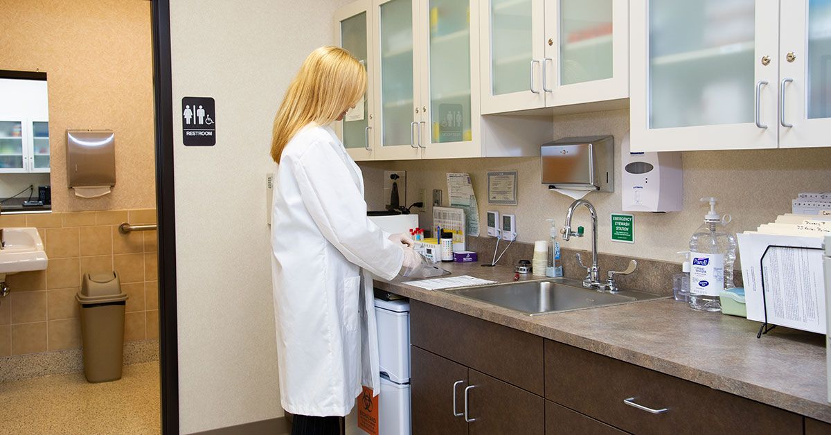 Medical professional in lab setting handling samples, illustrating voluntary use of surgical masks in non-respiratory hazard environments per OSHA guidance