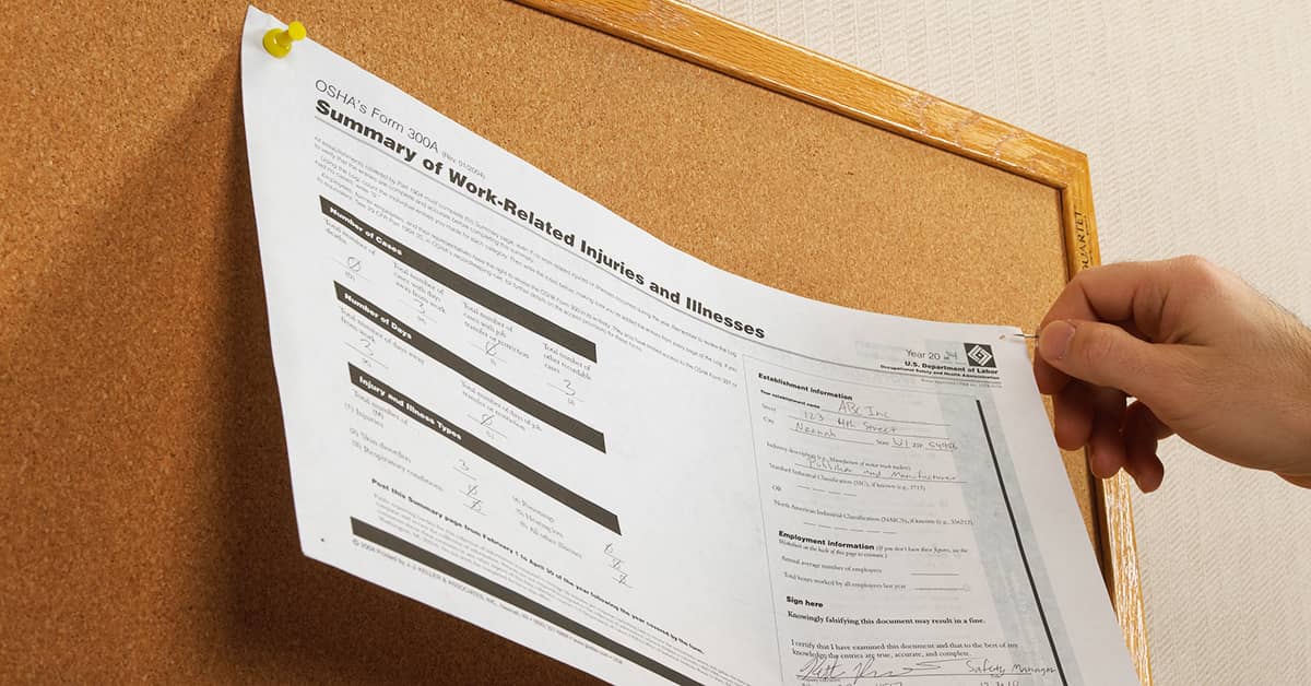Hand pinning OSHA Form 300A Summary of Work-Related Injuries and Illnesses to a corkboard.