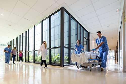 Hallway view of healthcare facility with patients and healthcare workers