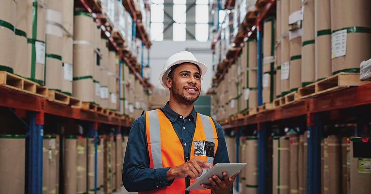 Man with clipboard inspecting a warehouse 