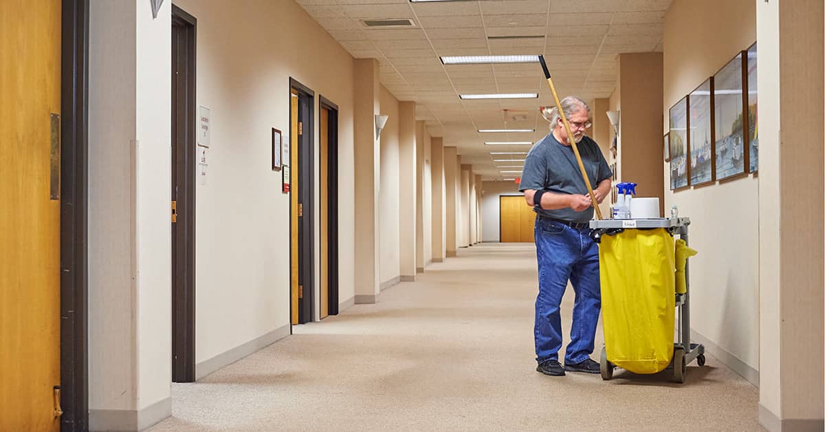 Janitor alone in a workplace hallway