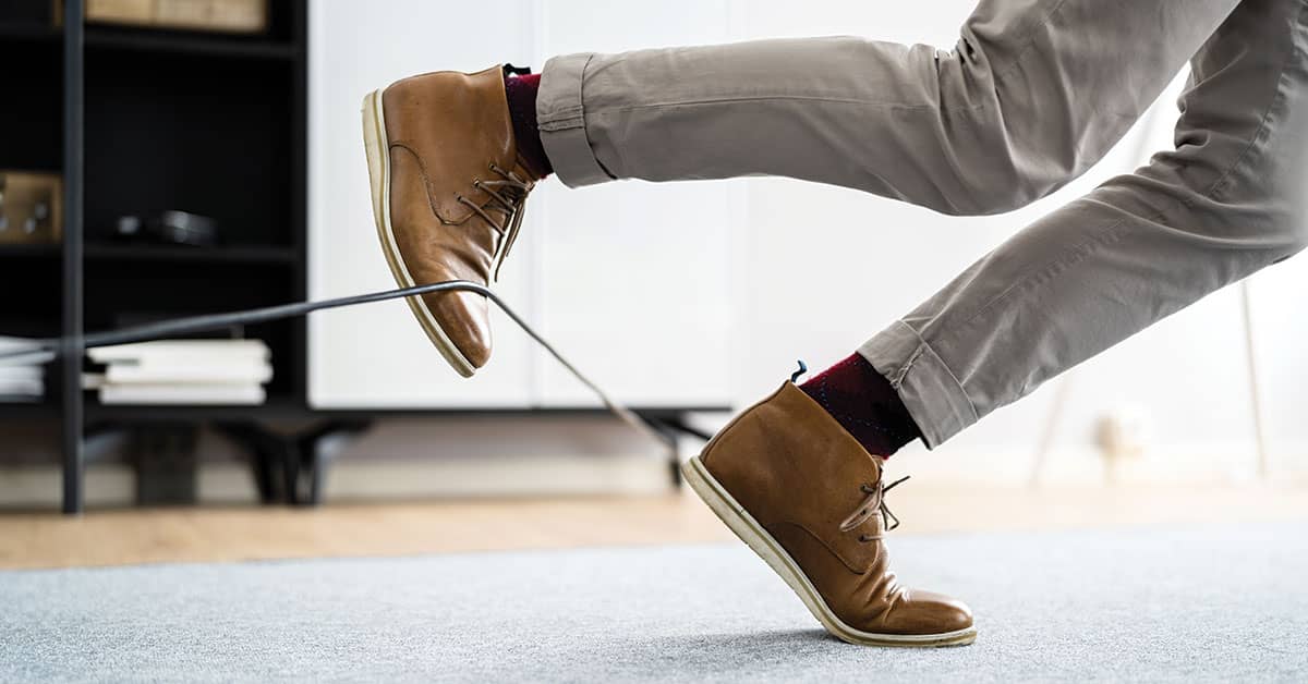 Man tripping on cord in office environment