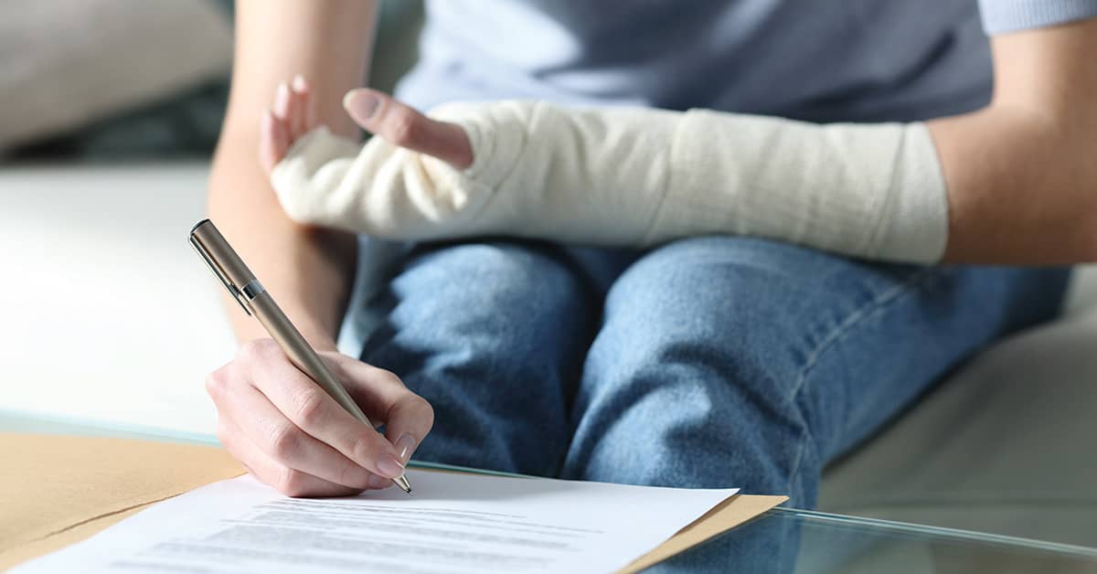 Woman with bandaged arm signing document