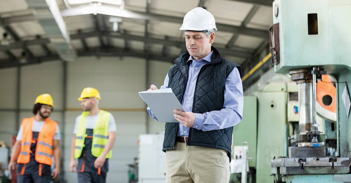 Inspector with clipboard in manufacturing setting