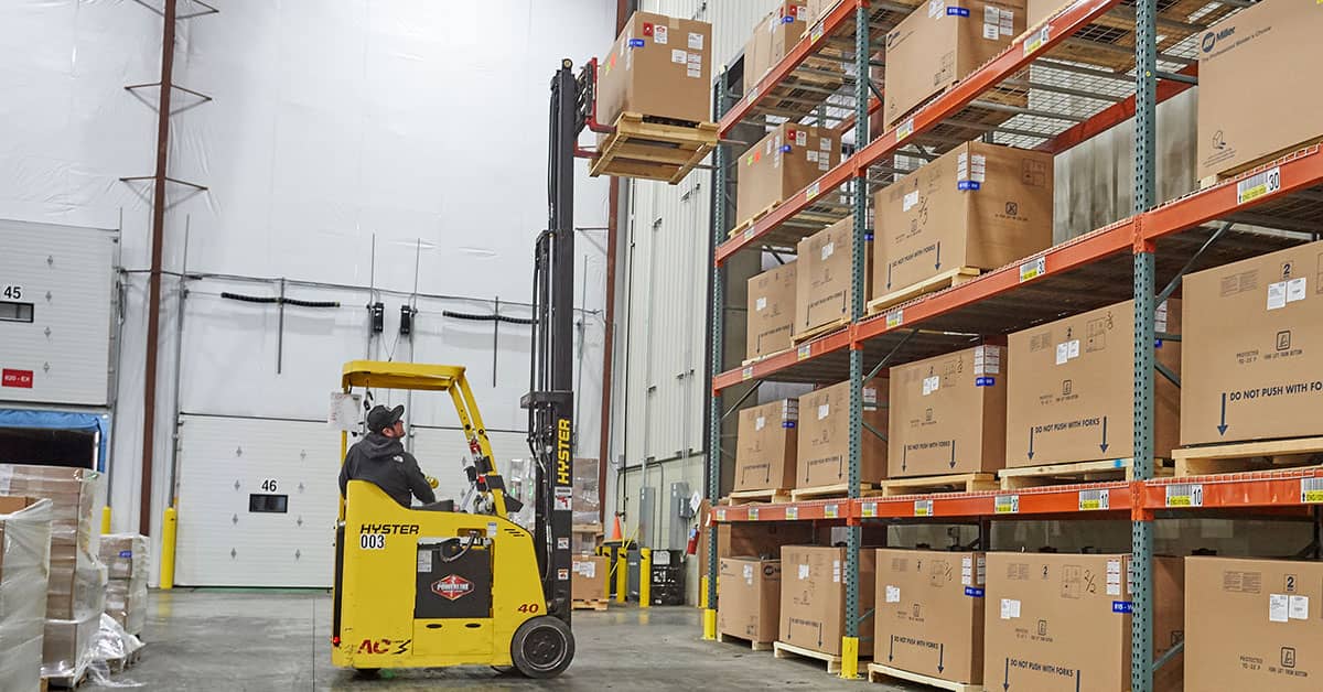 Stand-up Forklift in Warehouse